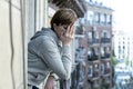 Young attractive unhappy lonely woman with depression looking sad on the balcony at home