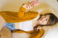 Young attractive and relaxed Asian Korean girl using mobile phone at home bedroom enjoying internet online dating app or social Royalty Free Stock Photo