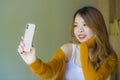 Young attractive and relaxed Asian Korean girl using mobile phone at home bedroom enjoying internet online dating app or social Royalty Free Stock Photo