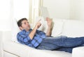 Young attractive 30s man using digital tablet pad lying on couch at home networking looking relaxed Royalty Free Stock Photo