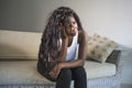 Young attractive and sad black African American woman sitting depressed at home sofa couch feeling anxious and frustrated sufferin Royalty Free Stock Photo