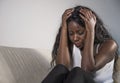 Young attractive and sad black African American woman sitting depressed at home sofa couch feeling anxious and frustrated sufferin Royalty Free Stock Photo