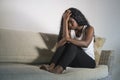 Young attractive and sad black African American woman sitting depressed at home sofa couch feeling anxious and frustrated sufferin Royalty Free Stock Photo