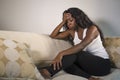 Young attractive and sad black African American woman sitting depressed at home sofa couch feeling anxious and frustrated sufferin Royalty Free Stock Photo