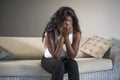 Young attractive and sad black African American woman sitting depressed at home sofa couch feelings anxious and frustrated sufferi Royalty Free Stock Photo