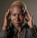 Young attractive and sad black afro American woman with fingers on her head tempo suffering headache and migraine feeling stressed Royalty Free Stock Photo