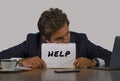 Young attractive sad and depressed business man working at office laptop computer desk holding notepad asking for help feeling des Royalty Free Stock Photo