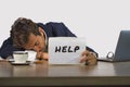 Young attractive sad and depressed business man working at office laptop computer desk holding notepad asking for help feeling des Royalty Free Stock Photo