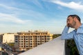 Young attractive, sad and desperate hispanic man suffering from depression who looks thoughtful and frustrated on the terrace of Royalty Free Stock Photo