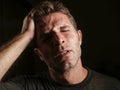 Young attractive and sad man suffering depression and headache with hand on his tempo head in stress looking worried and sick iso Royalty Free Stock Photo