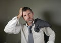 Young attractive sad and worried businessman in lose tie and messy look feeling depressed and stressed in overwhelmed and Royalty Free Stock Photo