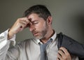 Young attractive sad and worried businessman in lose tie and messy look feeling depressed and stressed in overwhelmed face Royalty Free Stock Photo