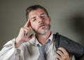 Young attractive sad and worried businessman in lose tie and messy look feeling depressed and stressed in overwhelmed face Royalty Free Stock Photo