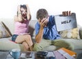 Young attractive sad and worried couple accounting together in financial stress at home couch in domestic finance problem Royalty Free Stock Photo