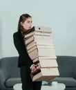 Young attractive secretary woman in a busy modern workplace in office. Pretty accountant girl holding many folders with Royalty Free Stock Photo