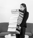 Young attractive secretary woman in a busy modern workplace in office. Pretty accountant girl holding many folders with Royalty Free Stock Photo