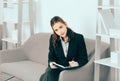 Young attractive secretary woman making notes in notebook in a busy modern workplace in office. Pretty accountant girl Royalty Free Stock Photo