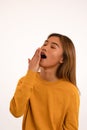 Young attractive sleepy asian girl yawning in studio