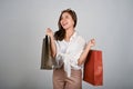 Young attractive and smiling Asian woman holding shopping bags, shopping concept Royalty Free Stock Photo