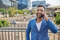 Portrait of smiling Indian businessman talking on mobile phone in city