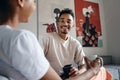 Young attractive smiling casual African American man joyfully looking in camera during coffee break in co-working space Royalty Free Stock Photo