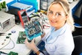 Female electronic engineer holding computer motherboard in hands