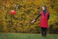 Young attractive smiling pregnant woman in red dress, holding red balloon in hand. Autumn park, 9 months pregnancy