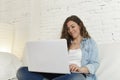 Young attractive spanish woman using laptop computer sitting relaxed working on home couch Royalty Free Stock Photo