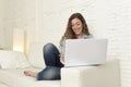 Young attractive spanish woman using laptop computer sitting relaxed working on home couch Royalty Free Stock Photo