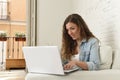 Young attractive spanish woman using laptop computer sitting relaxed working on home couch Royalty Free Stock Photo