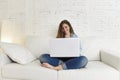 Young attractive spanish woman using laptop computer sitting relaxed working on home couch Royalty Free Stock Photo