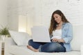 Young attractive spanish woman using laptop computer sitting relaxed working on home couch