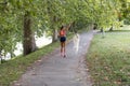 Young attractive sport girl running with dog in park Royalty Free Stock Photo