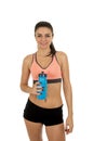 Young attractive sport woman in fitness clothes smiling happy posing with water bottle