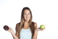 Young sport woman holding apple and chocolate donut in her hands in healthy fruit versus sweet junk food temptation Royalty Free Stock Photo