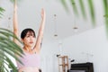 Young attractive sporty Asian woman practicing yoga, doing Virabhadrasana 1 exercise, meditating in Warrior One yoga pose. Royalty Free Stock Photo