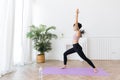 Young attractive sporty Asian woman practicing yoga, doing Virabhadrasana 1 exercise, meditating in Warrior One yoga pose Royalty Free Stock Photo