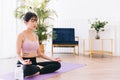 Young attractive sporty Asian woman practicing yoga on a yoga mat, doing Ardha Padmasana exercise, meditating in Half Lotus pose. Royalty Free Stock Photo