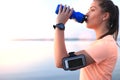 Young attractive sporty fitness woman drinking water exercise in beach outdoor portrait, at sunset or sunrise. Royalty Free Stock Photo