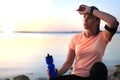 Young attractive sporty fitness woman drinking water exercise in beach outdoor portrait, at sunset or sunrise. Royalty Free Stock Photo