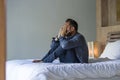 Young attractive stressed and depressed man sitting on bed worried and frustrated suffering depression crisis covering face with Royalty Free Stock Photo