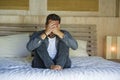 Young attractive stressed and depressed man sitting on bed worried and frustrated suffering depression crisis covering face with Royalty Free Stock Photo
