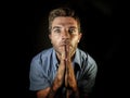 Young attractive stressed man with hands palms together praying and wishing success to come looking concentrated hoping for good l Royalty Free Stock Photo