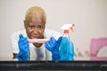 Young attractive stressed and upset back afro American woman in washing rubber gloves cleaning home kitchen tired and overworked i Royalty Free Stock Photo