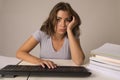 Young attractive student girl or working woman sitting at computer desk in stress looking tired exhausted and boring Royalty Free Stock Photo