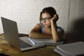 Young attractive student girl or working woman sitting at computer desk in stress looking tired exhausted and boring Royalty Free Stock Photo