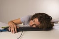 Young attractive student girl or working woman sitting at computer desk in stress sleeping tired exhausted and boring Royalty Free Stock Photo