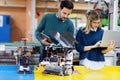 Young attractive students of mechatronics working on project