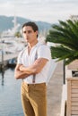 Young Attractive stylish man walks along the pier with yachts and hotels. Portrait of Male model Royalty Free Stock Photo