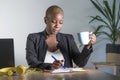Young attractive and successful black afro american woman in business jacket working serious at office laptop taking notes writing Royalty Free Stock Photo